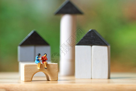 微型商人坐在木头上投资分析住房或动产投资图片