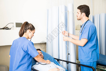 医生检查躺在医院床上的病人图片