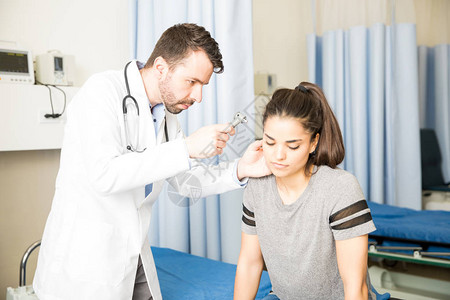 医生在例行检查时使用眼镜检查女病人的耳朵图片