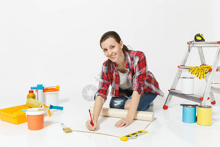 女人坐在墙纸卷尺铅笔翻新公寓的工具上图片
