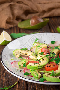 蔬菜沙拉配鳄梨芝麻菜萝卜酸橙和橄榄油饮食健康食品木质朴的图片