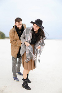 快乐的女孩和男人穿着外套和围巾站在冬天的雪背景中幸福夫妻和积图片