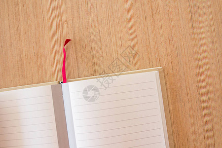 办公桌木制办公桌背景上的空白笔记本页面带有文本或设计复制图片