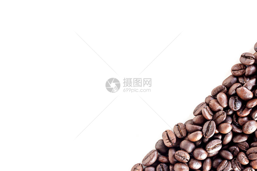 在白桌背景区域与白桌边隔开供复制空间的烤咖啡豆最顶端视图咖啡豆用图片