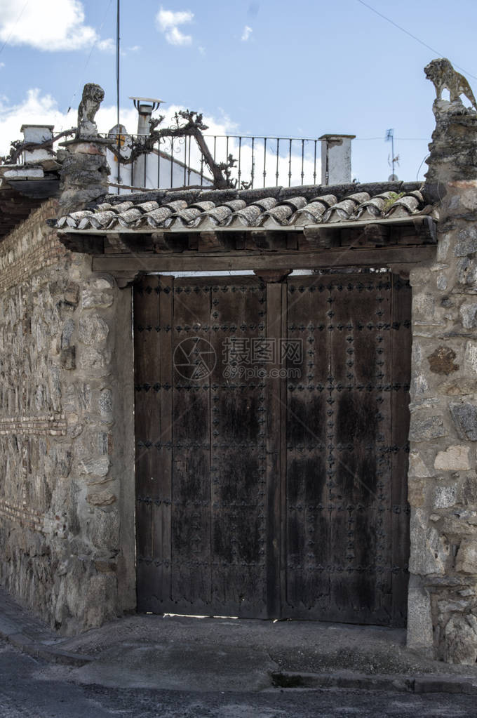 大木门托莱多省普埃布拉德蒙塔尔班一所房子的石头立面上带屋顶的木门卡斯蒂利亚图片