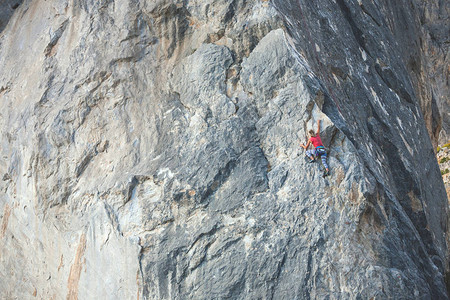 岩石上的女人登山者在自然浮雕上训练积极的生活方式在图片