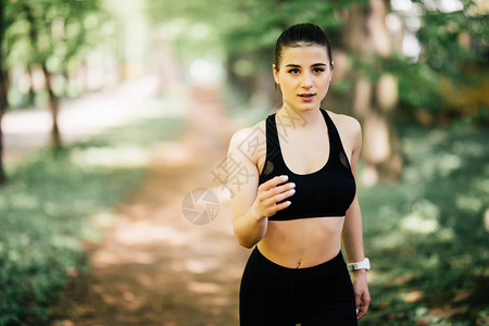奔跑的女人在公园户外锻炼期间慢跑的女跑步者美丽适合的女孩户外健图片