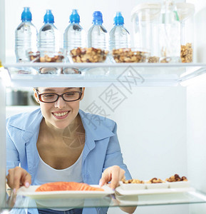 快乐的女人打开冰箱前有蔬菜图片
