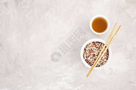 陶瓷碗和有绿茶的筷子中各种多色野生大米图片