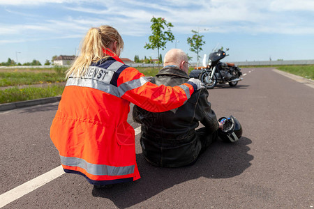一名德国医护人员帮助受伤的摩托车手图片
