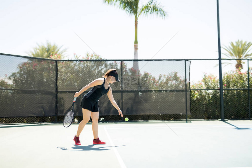 网球玩家站在打球的底线上在网球比赛中图片