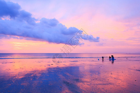 美丽的乌云和日落的天空当地的渔夫和家人在长沙滩图片