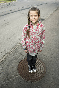 位于城市空街金属密室中心的女童孩站在空图片