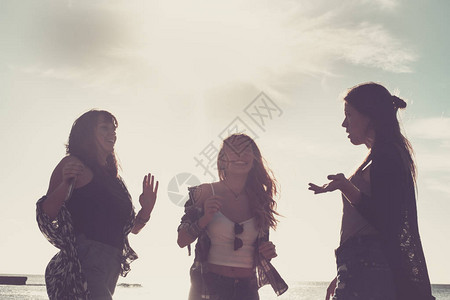 三名年轻美女在度假期间在海滩跳舞的关系图片
