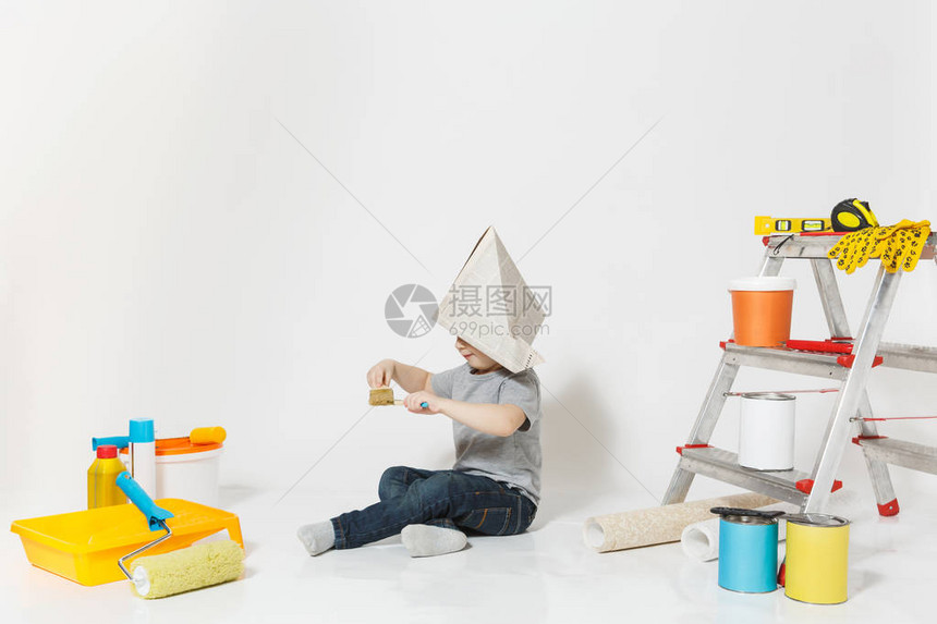 小可爱男孩在报纸帽子与仪器翻新公寓房间隔离在白色背景壁纸胶合配件绘画工具修家为人父图片