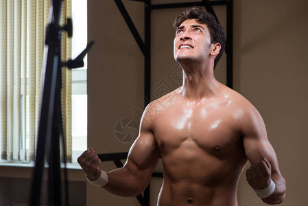 在健身房做运动的被撕破的肌肉男图片
