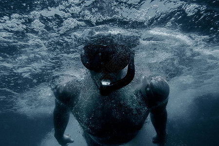 运动的年轻男子自由潜水图片