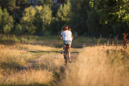 年轻少女在田径上骑脚踏自行图片