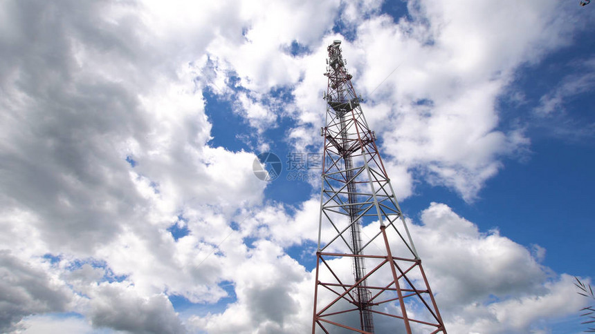 反对蓝天的手机塔与许多不同的天线在蓝天和云彩下的通信塔与图片