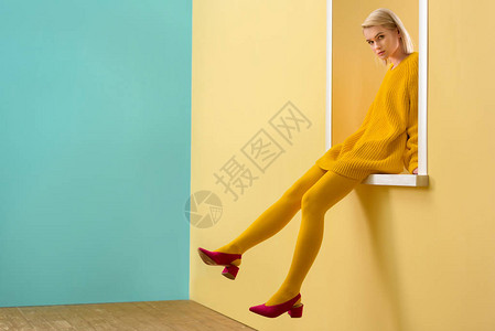 穿粉红色鞋黄色毛衣和穿着装饰窗户的紧身衣服的时图片