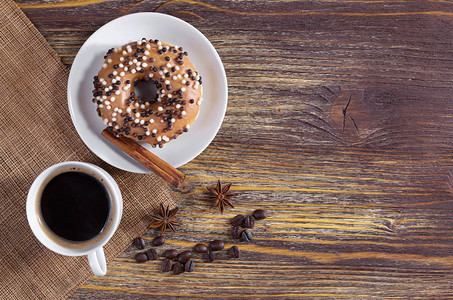 由白色和深黑巧克力球装饰的咖啡和甜圈杯位于一个旧木制表面图片