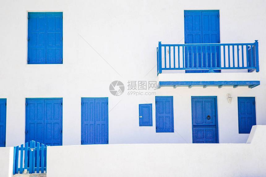 希腊Mykonos狭小的街道上有蓝色门窗的传统房屋校图片