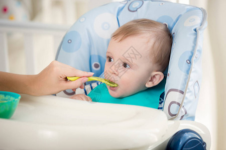 男婴用勺子吃水果酱的特写肖像图片