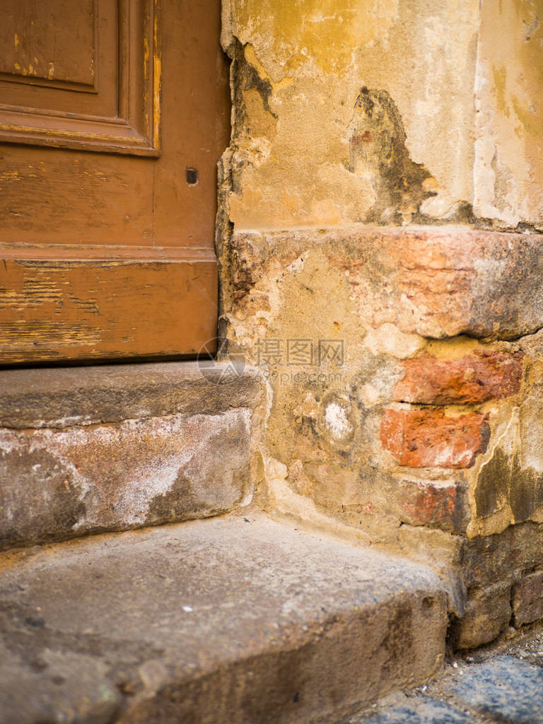 旧木门风化破裂的油漆如此古老的木门在一座古老的石屋的墙上有水泥抹灰的老街道入口门图片