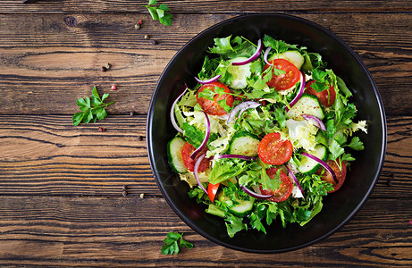 素食沙拉配西红柿黄瓜红洋葱和莴苣叶的顶部视图健康的夏季维生素菜单素食蔬菜食品背景图片