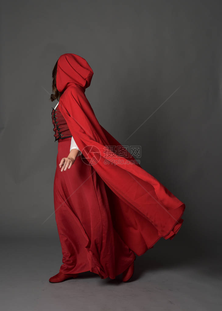 穿着红色幻想服的黑发女士长肖像披着斗篷穿着灰色工作图片