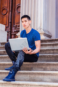 年轻的亚裔美国人在纽约学习工作穿着蓝色T恤黑色裤子运动鞋图片