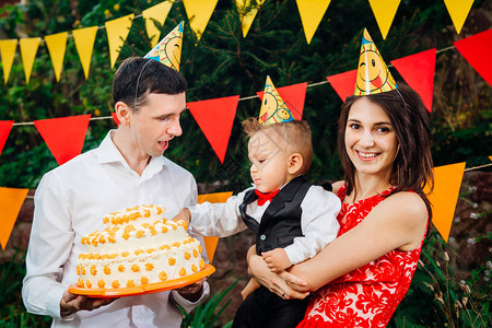 主题儿童的生日派对食物和糖果一个年轻的家庭庆祝儿子一周岁爸拿着一个大蛋糕背景图片