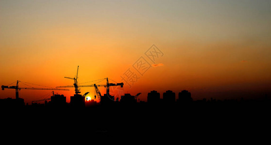 日落时的Silhouette起重机建筑大楼图片