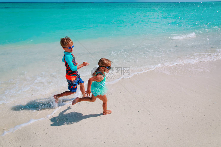 女孩和男孩在海滩上玩水家图片