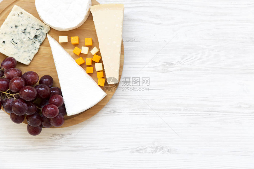白木背景的乳酪和葡萄尝起来图片