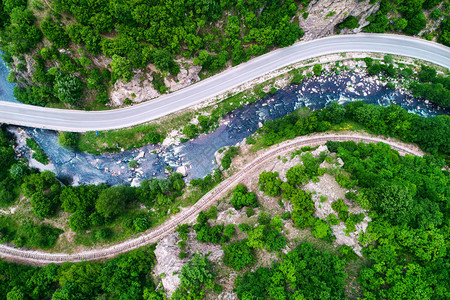 无人驾驶飞机在山区公路和横跨森林地貌的曲线图片