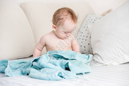 男婴洗完澡后坐在毛巾上图片
