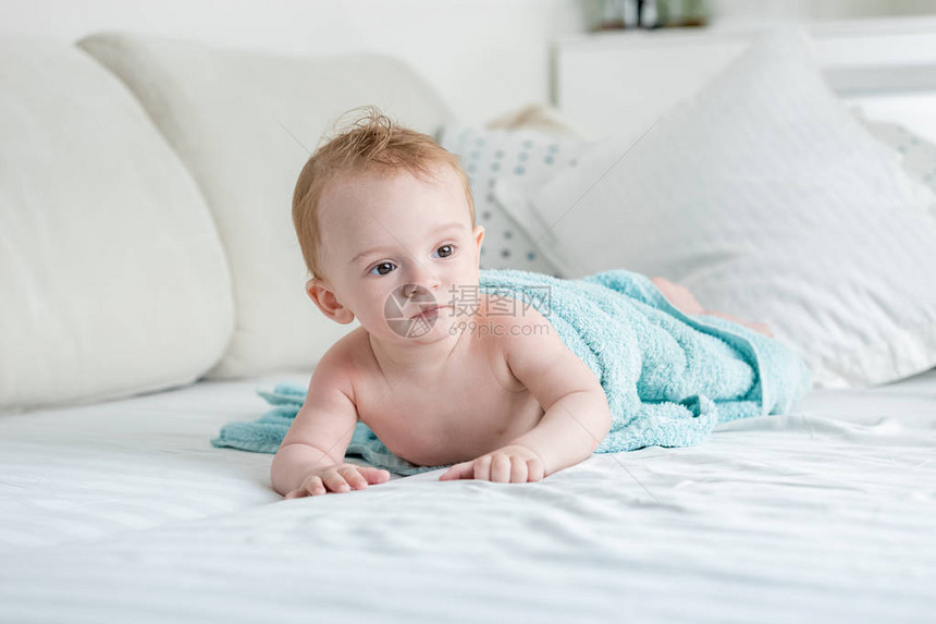 9个月大的婴儿男孩洗完澡后躺在大蓝图片
