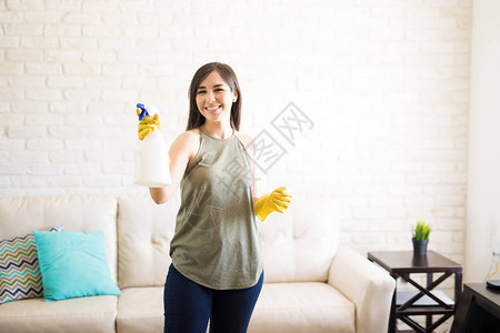 年轻女子在打扫房子时使用喷雾剂图片