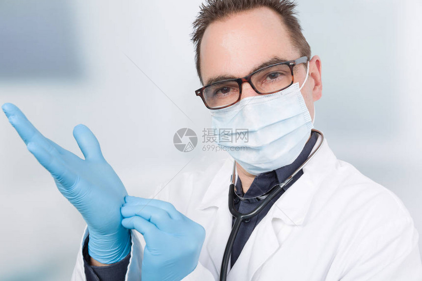 戴医用口罩的医生正在使用医手套图片