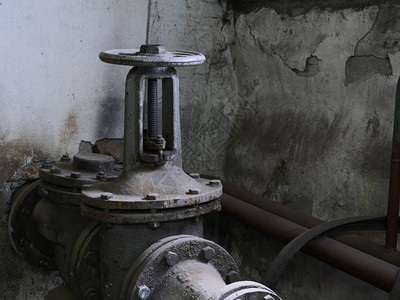 地下室管道上的旧铸铁阀门图片