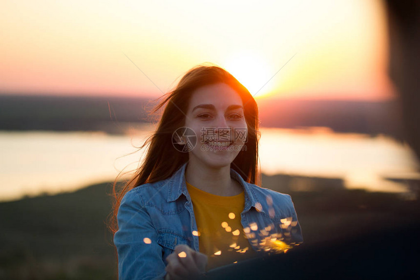 快乐的年轻女子的肖像在夏日傍晚图片