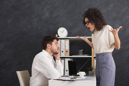 在现代办公室争论的年轻同事的情感夫妇图片