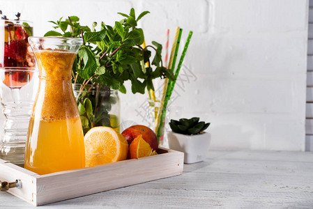 厨房桌上的木质托盘里含脚衣和薄荷的橙色柠檬图片