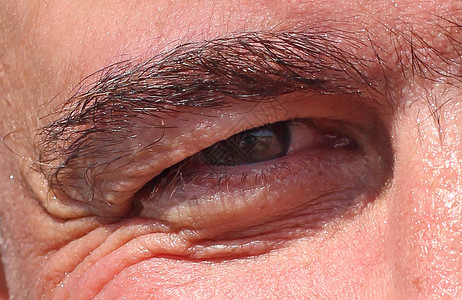 一个成熟男人的脸部的一部分眼睛在角落中皱纹图片