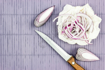 一圈紫洋葱和一把刀光桌上的新鲜红洋葱图片