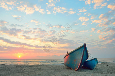 日出时在海滩上的渔船图片