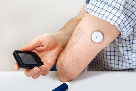 男人用数字血糖仪测试血糖水平图片