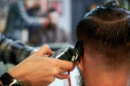 师傅在理发店剪男人的头发和胡须理发师为图片