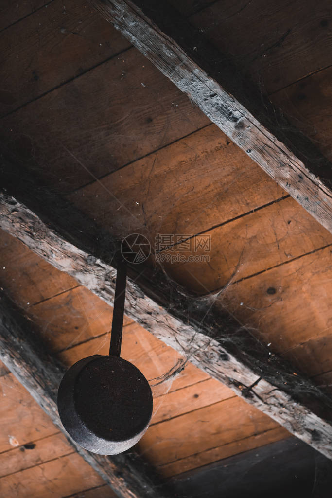被蜘蛛网覆盖的老煎锅从天花板上挂在一座图片